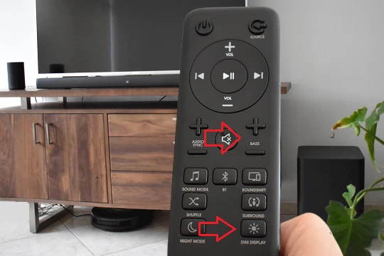 The image shows a JBL soundbar remote control highlighting the DIM display and Bass buttons.